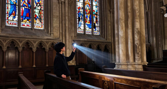 a beam of white light carves through paris’ historical chapel